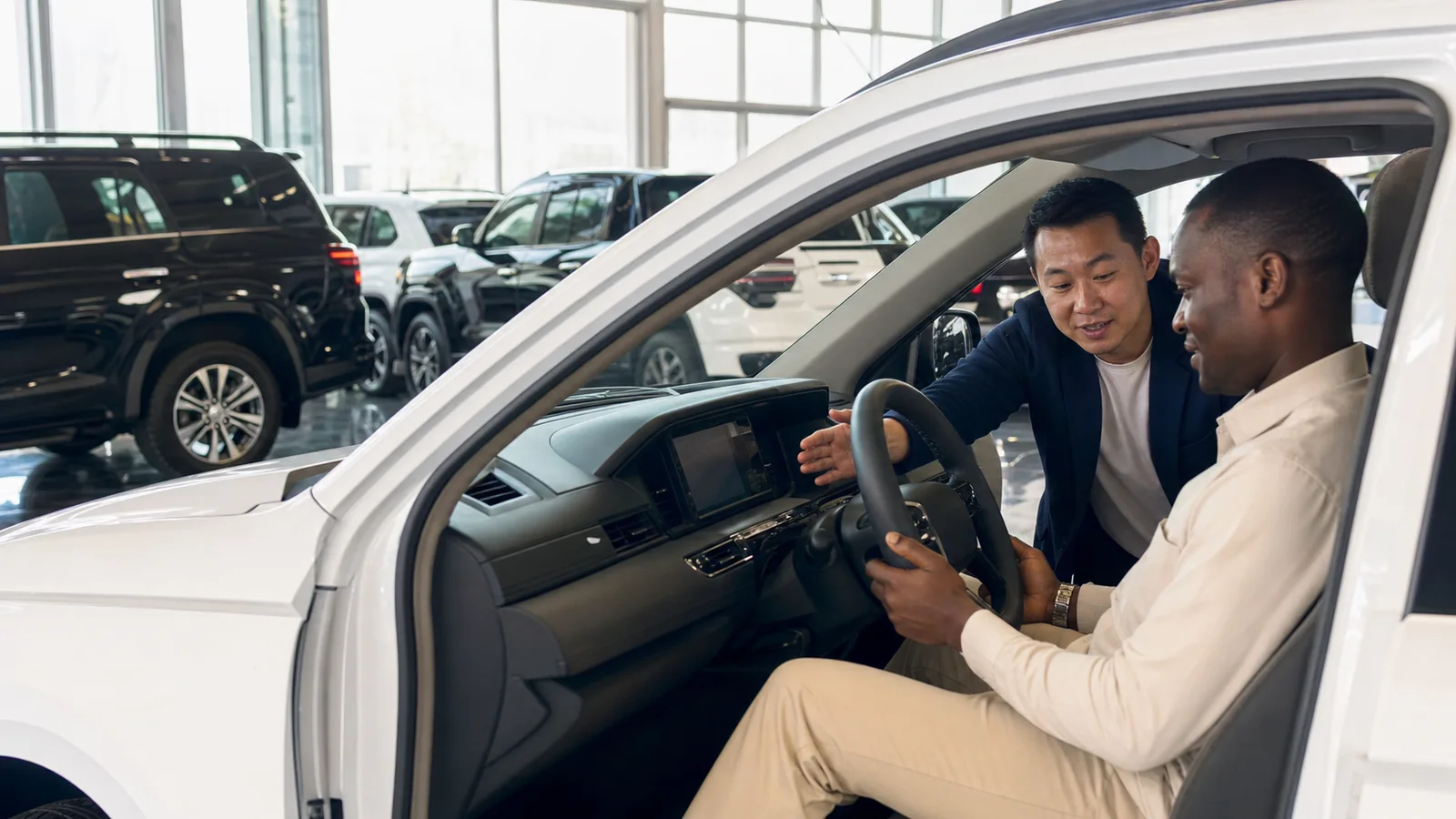 Overseas buyer testing the right-hand-drive position of a used SUV in a China vehicle showroom